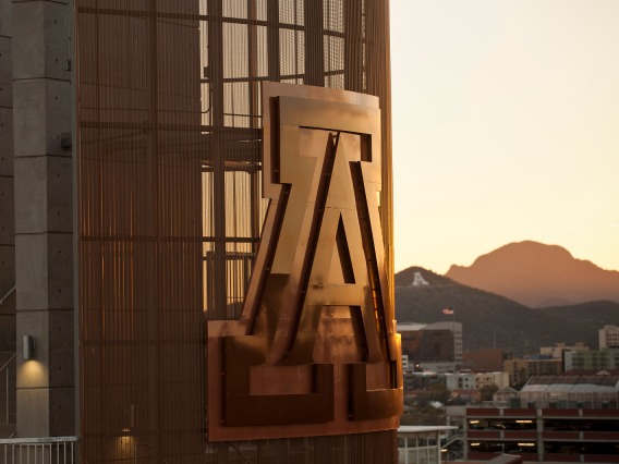 Picture of sunset with a big metal letter A, which is the university logo. 